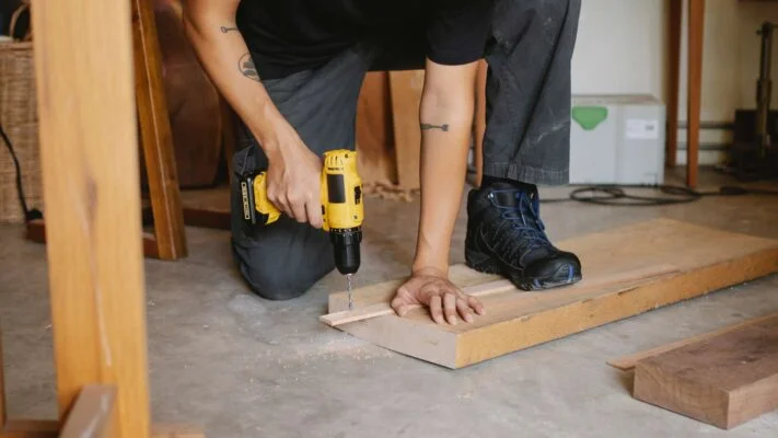 Image d’une visseuse perceuse sans fil en train d’être utilisée sur un chantier.